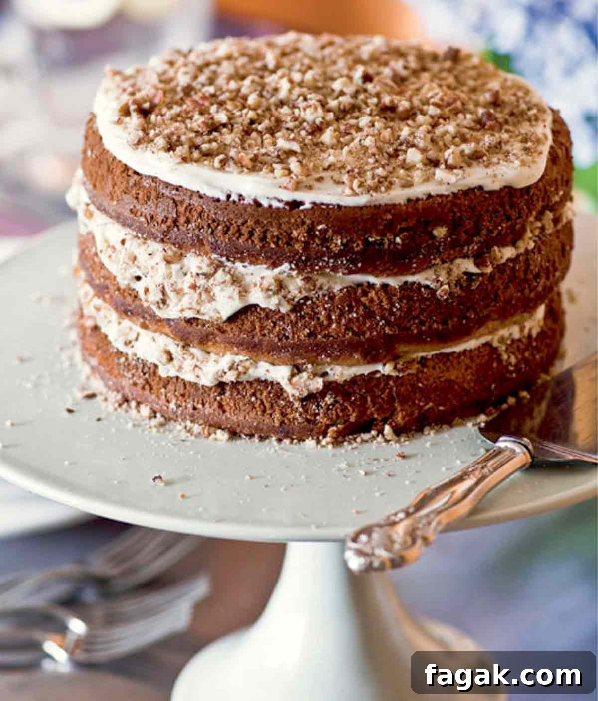 A three-layer hummingbird cake with a cake server beside it.
