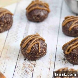 Paleo Dark Chocolate Bliss Balls Recipe for Quick Snacks 15 Chocolate balls with dairy-free caramel sauce piped onto them.