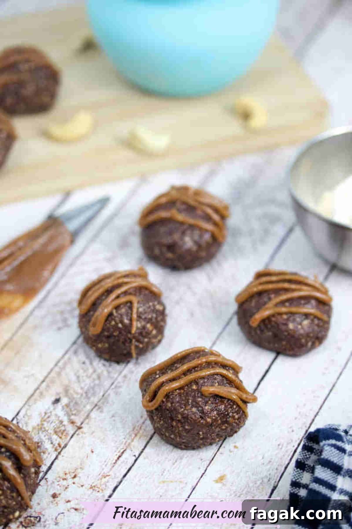Paleo Dark Chocolate Bliss Balls Recipe for Quick Snacks 10 Chocolate balls with dairy-free caramel sauce piped onto them.