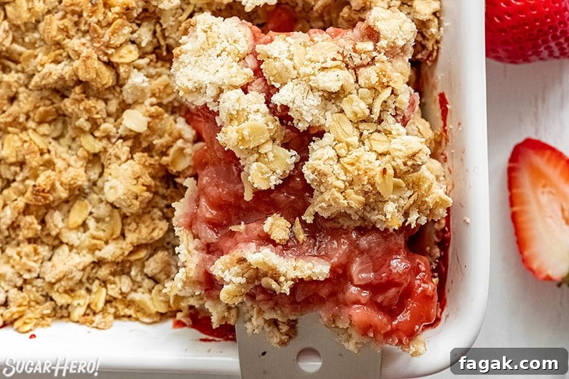 Spatula removing a serving of Strawberry Crisp from the baking pan.