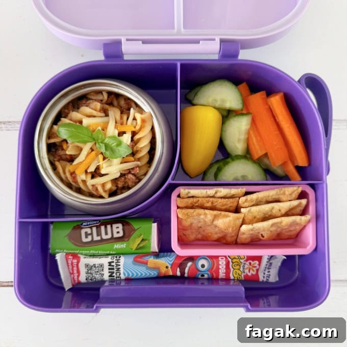 Leftover Spaghetti Bolognese served in a bright purple hot & cold lunch box, served with chopped,fresh veggies.