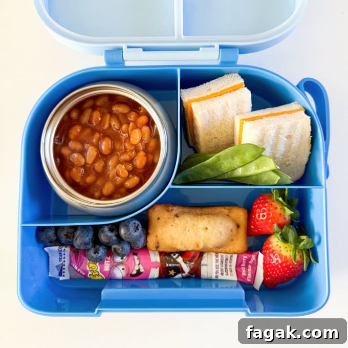 Baked beans in a thermos pot served with a cheese sandwich and other treats.