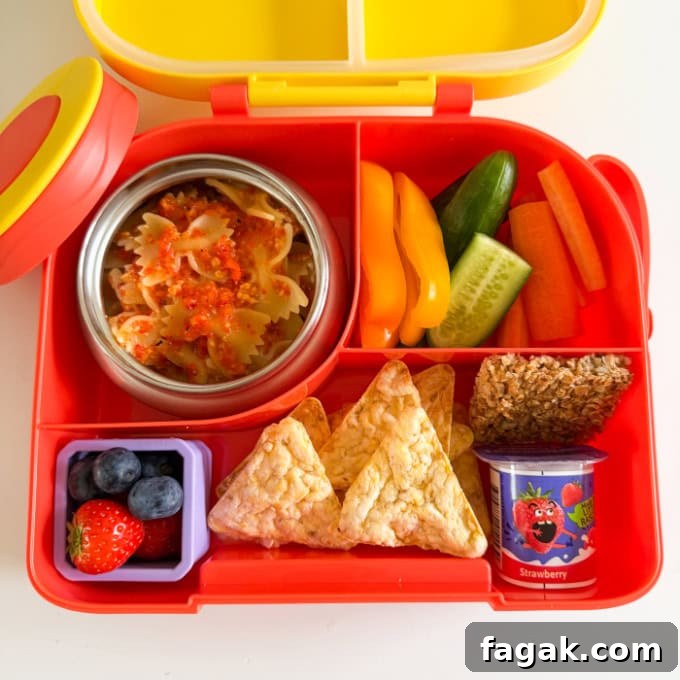 Red Pepper Pasta served in a bright red hot & cold lunch box with sliced,fresh veggies.