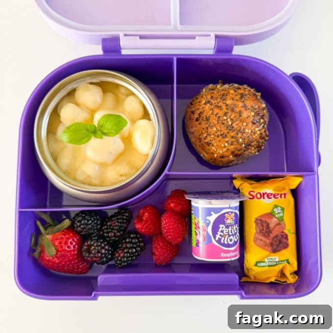 Gnocchi Mac & Cheese served in a bright purple hot & cold lunch box. with fresh berries and a seeded roll.