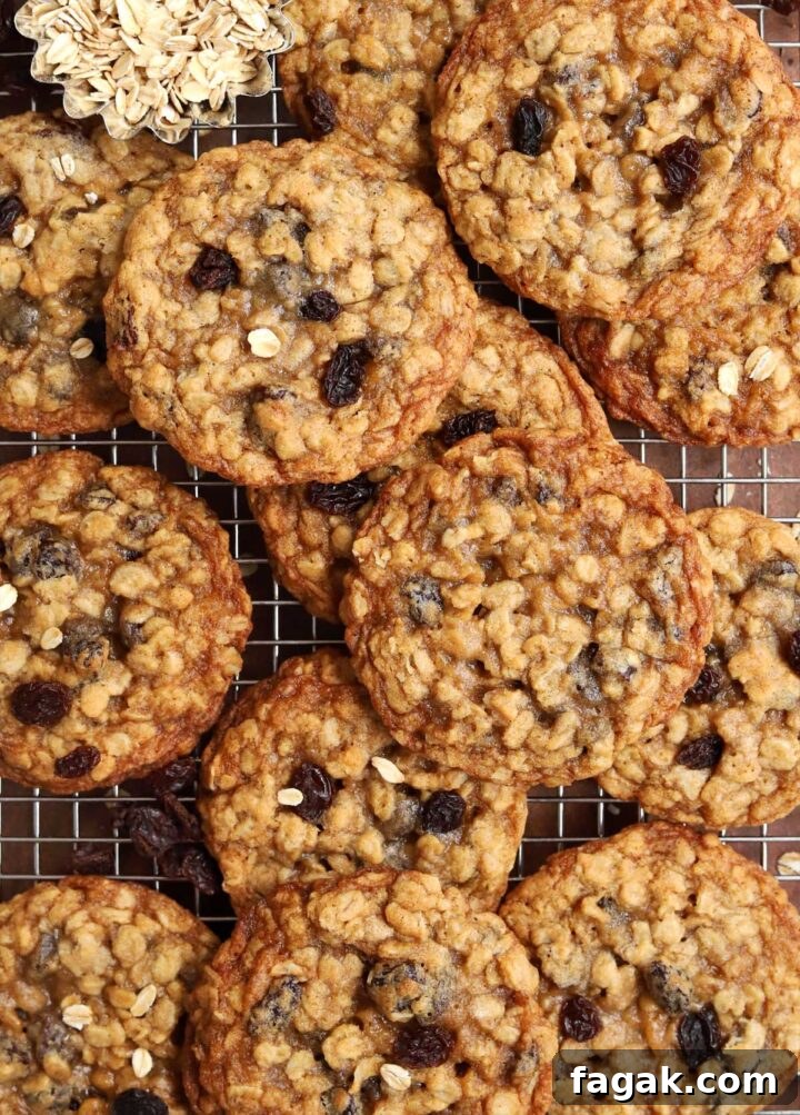 chewy oatmeal raisin cookies piled up on a cooling rack