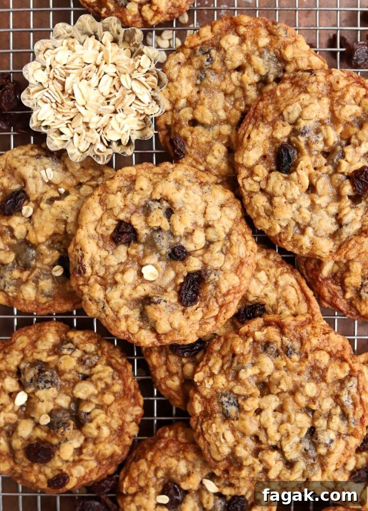 chewy oatmeal raisin cookies piled up on a cooling rack