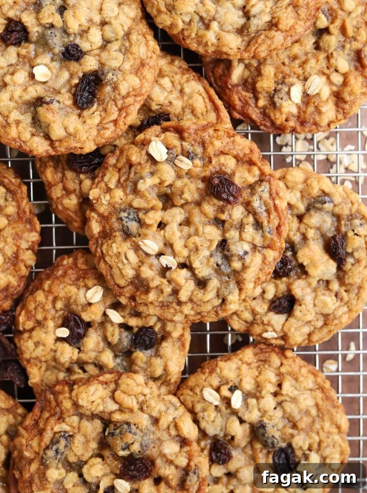 chewy oatmeal raisin cookies piled up on a cooling rack
