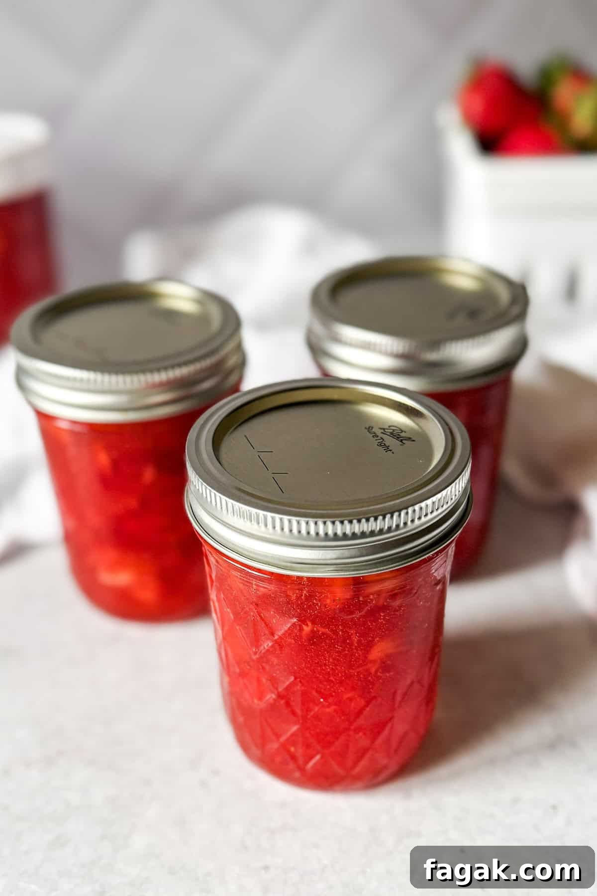 Jars of homemade strawberry freezer jam made with fresh strawberries.