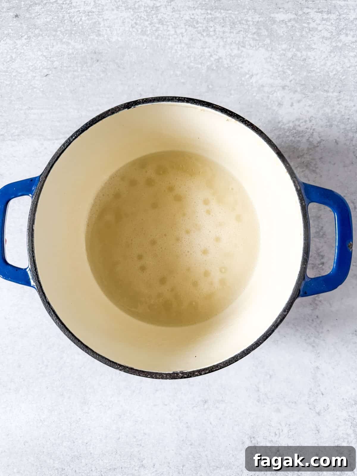 Pectin and water coming to a boil in a saucepan.
