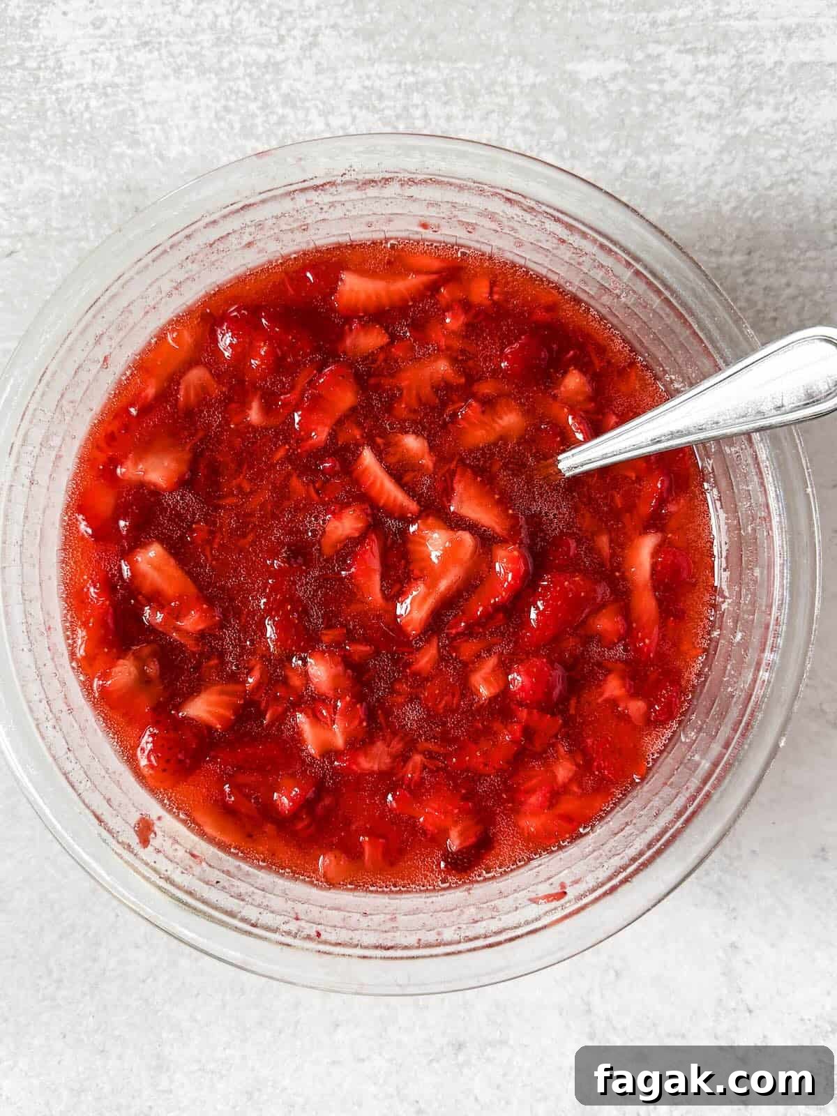 Strawberry freezer jam thickening after mixing with sugar and pectin.