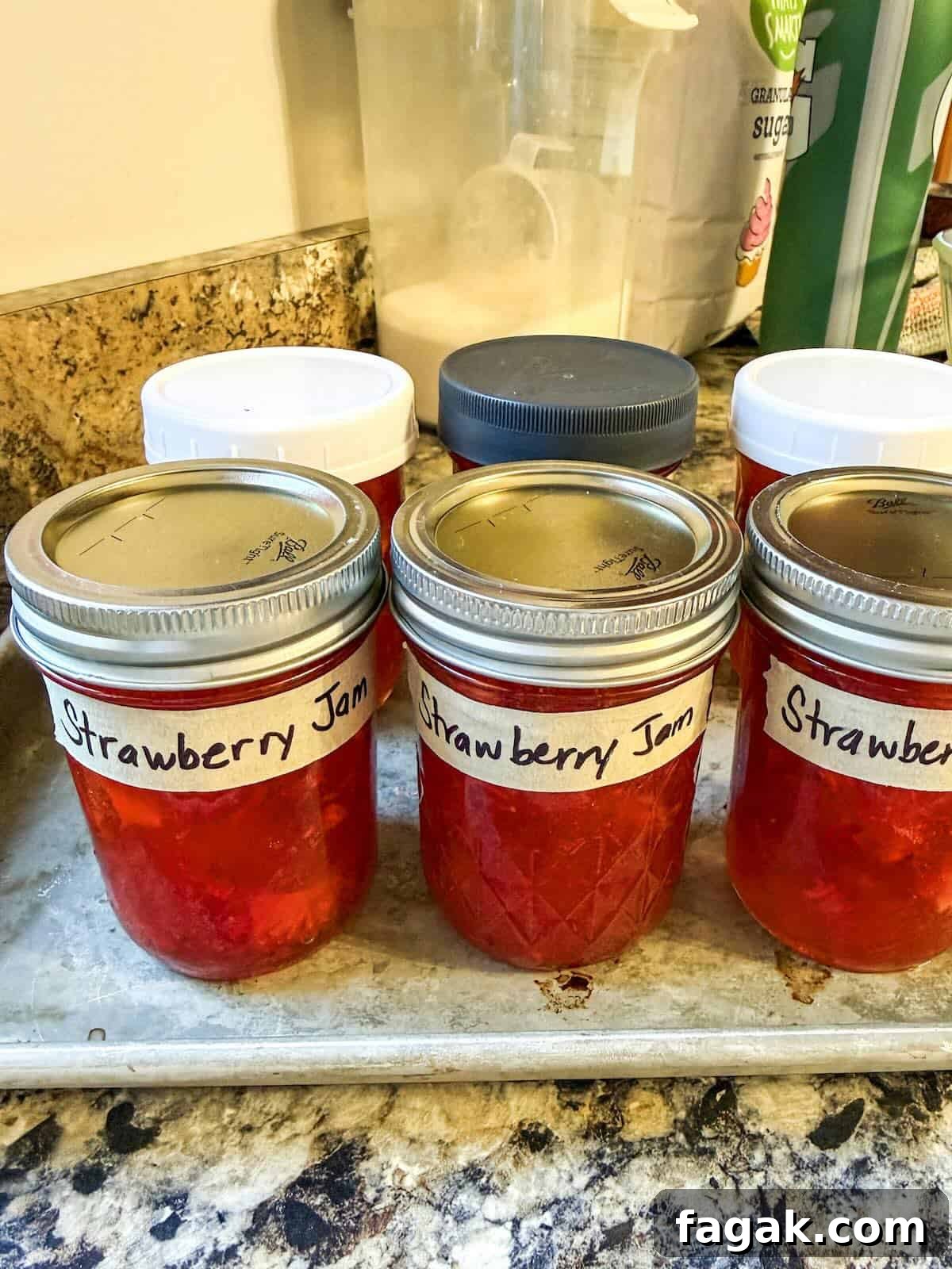 Strawberry freezer jam in mason jars labeled and ready to freeze.