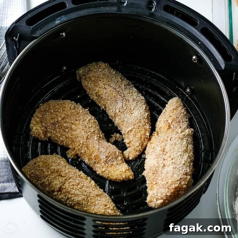 top view of breaded chicken tenders in an air fryer basket