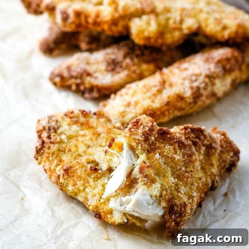 close up of cooked chicken tenders on parchment paper