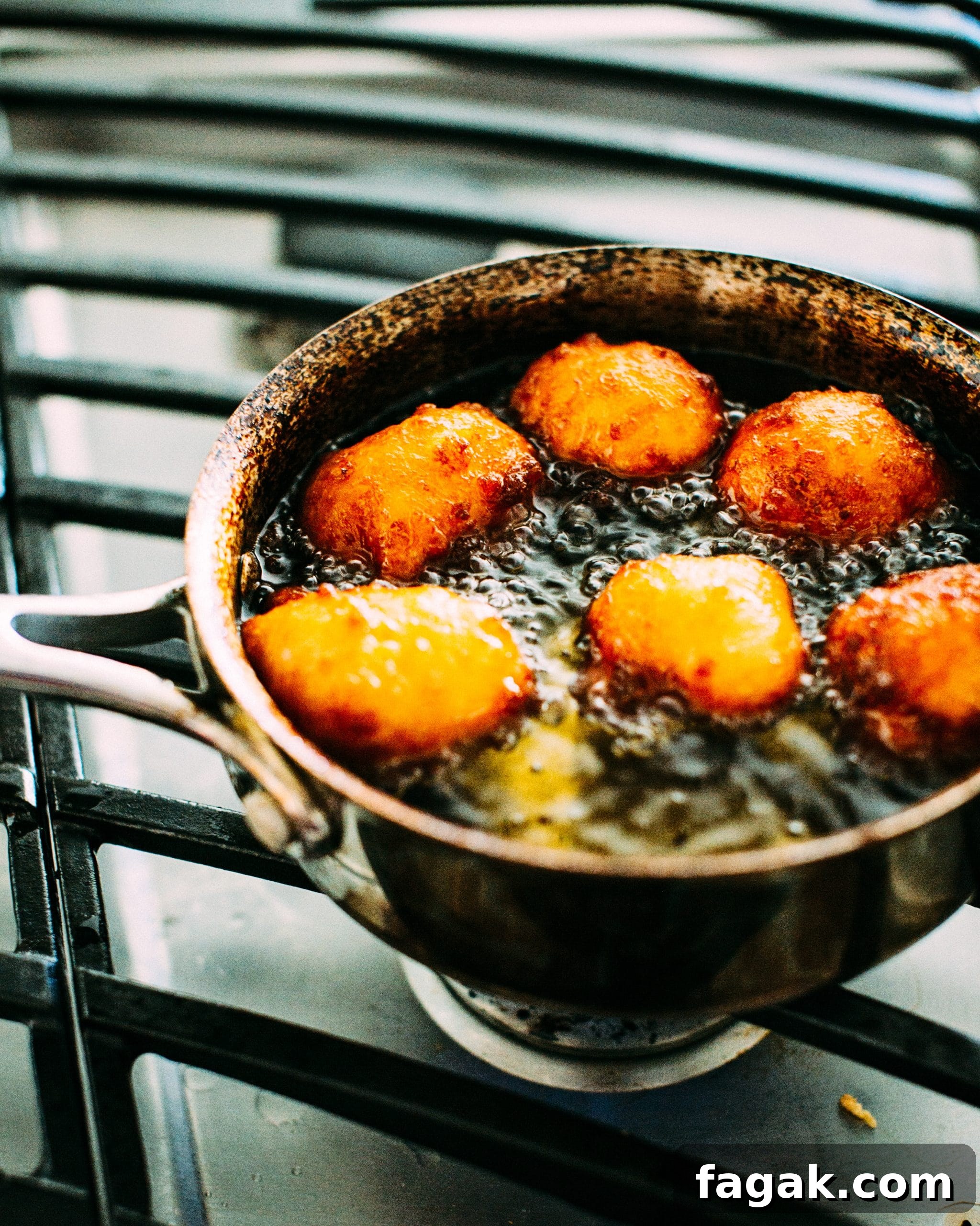 gulab jamun being fried on a stovetop