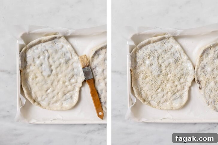 Foolproof Keema Naan Recipe: Step-by-Step Guide for Perfect Stuffed Bread 14 Keema Naan on a baking sheet brushed with butter and sprinkled with sesame seeds ready to be baked.