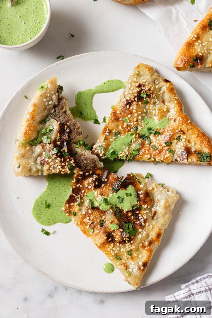Foolproof Keema Naan Recipe: Step-by-Step Guide for Perfect Stuffed Bread 17 Partially eaten slices of Keema Naan on a plate drizzled with raita.