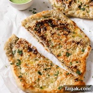Foolproof Keema Naan Recipe: Step-by-Step Guide for Perfect Stuffed Bread 20 Baked Keema Naan cut in half and sprinkled with cilantro with raita on the side for dipping.