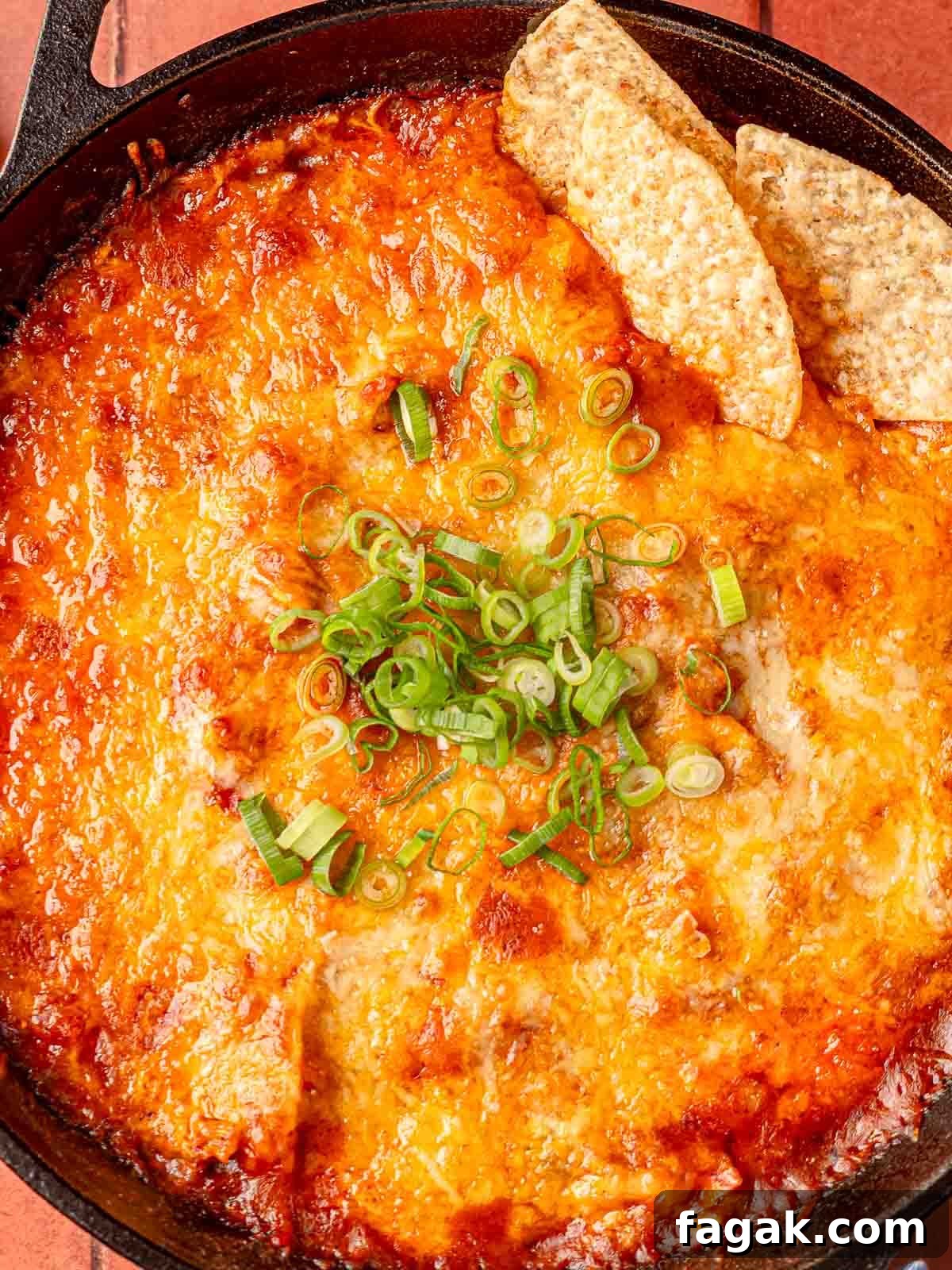 Cheesy Baked Chicken Enchilada Dip Without Cream Cheese 2 Chicken enchilada dip in a cast iron skillet topped with diced green onions.