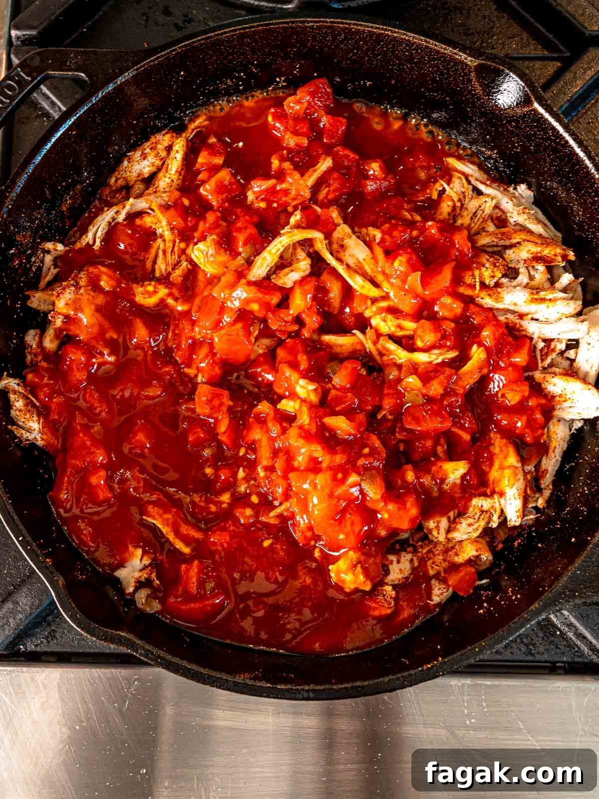 Cheesy Baked Chicken Enchilada Dip Without Cream Cheese 5 Diced tomatoes, cooked chicken and spices cooking in a skillet.