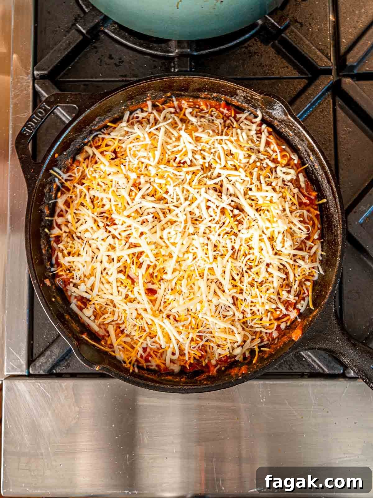 Cheesy Baked Chicken Enchilada Dip Without Cream Cheese 7 Shredded cheese on top of enchilada dip before baking.