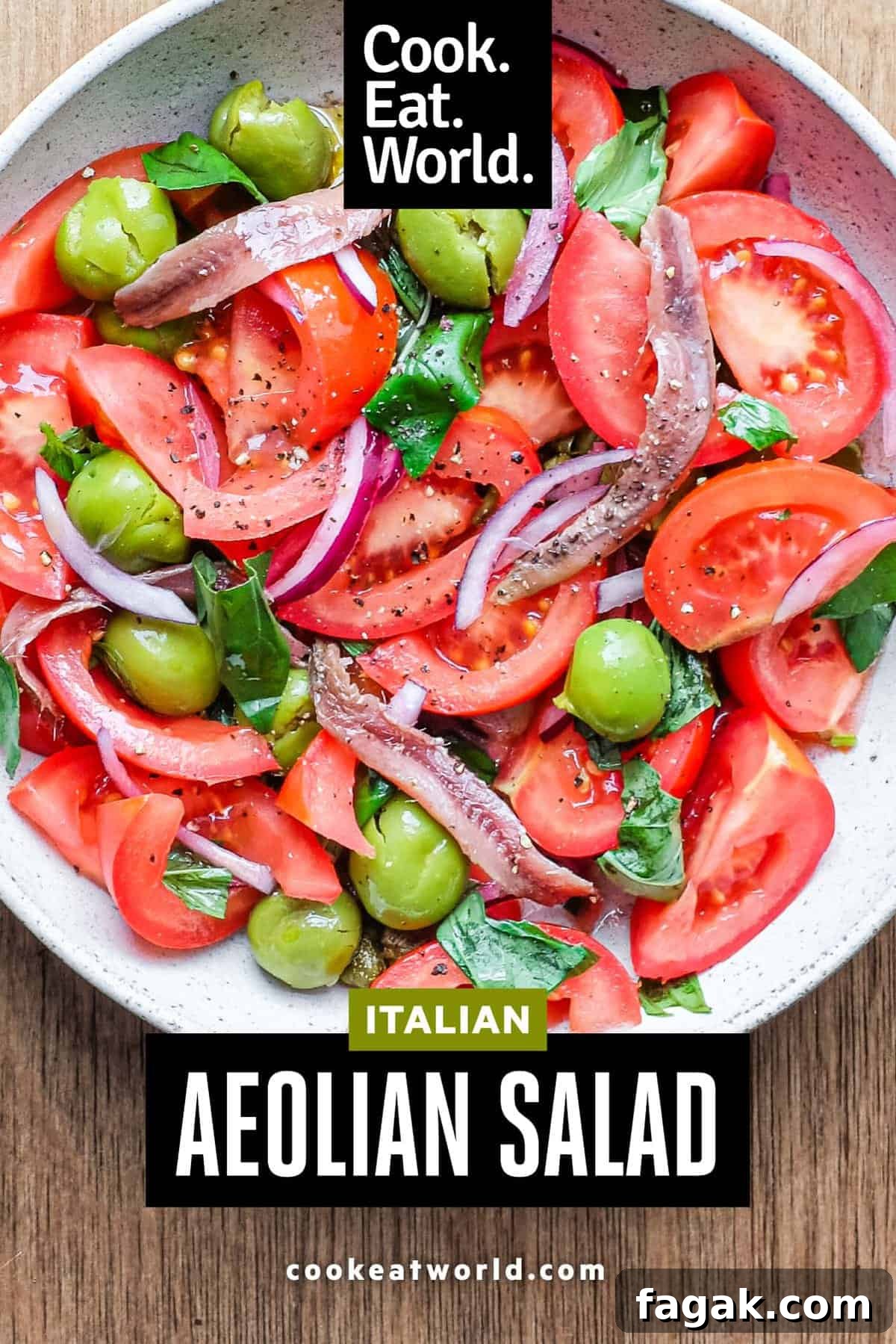 A bowl of Tomato salad with olives, capers, red onion, anchovies and fresh basil.