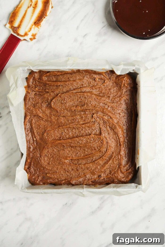 Date caramel spread into an even layer in a square baking pan.