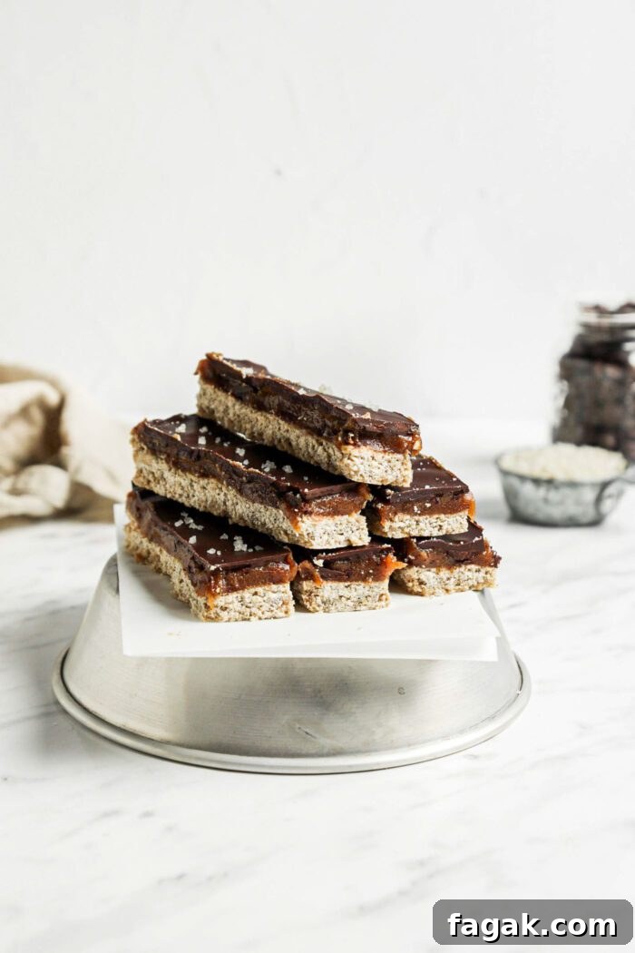 Stack of 6 homemade Twix candy bars on an upside down metal bowl lined with parchment paper.