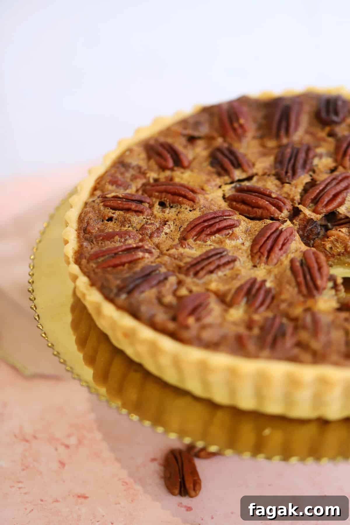 A gluten free pecan pie on a gold plate.