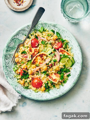 Halloumi Couscous Salad with Lemon on a green plate with a fork.