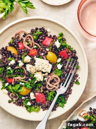 Black Lentil Salad with Feta in a bowl with a fork.