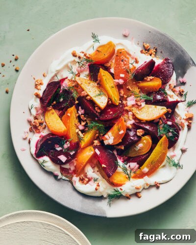 Labneh topped with roasted beets and fresh herbs on a light green table