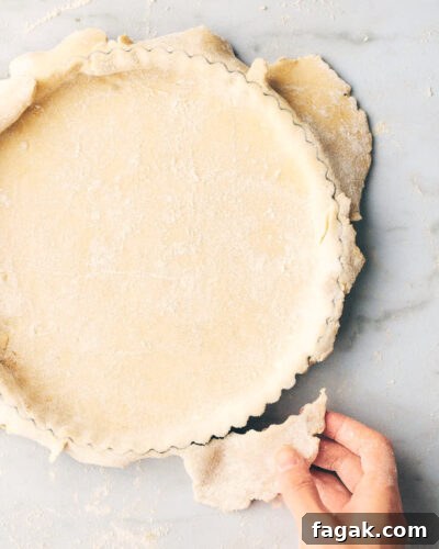 Quiche crust being prepped for baking in a pan