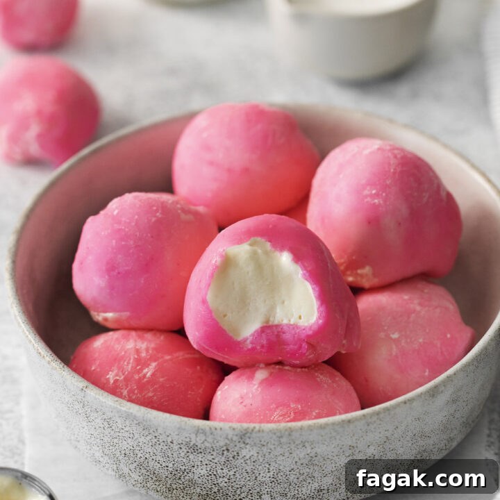 a bowl of homemade mochi with pink coating, filled with vanilla ice cream.