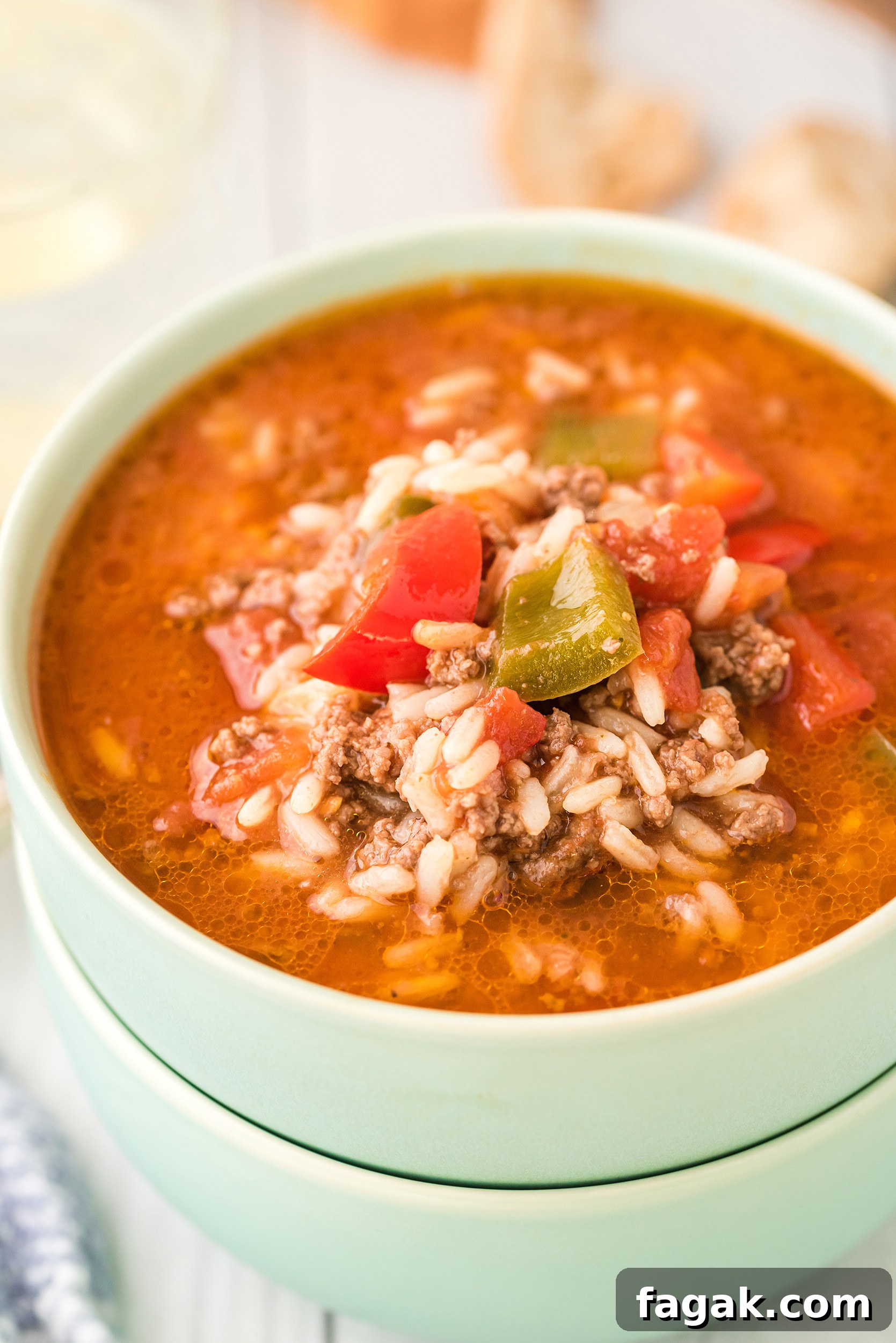 two stacked mint green bowls bowls filled with stuffed pepper soup