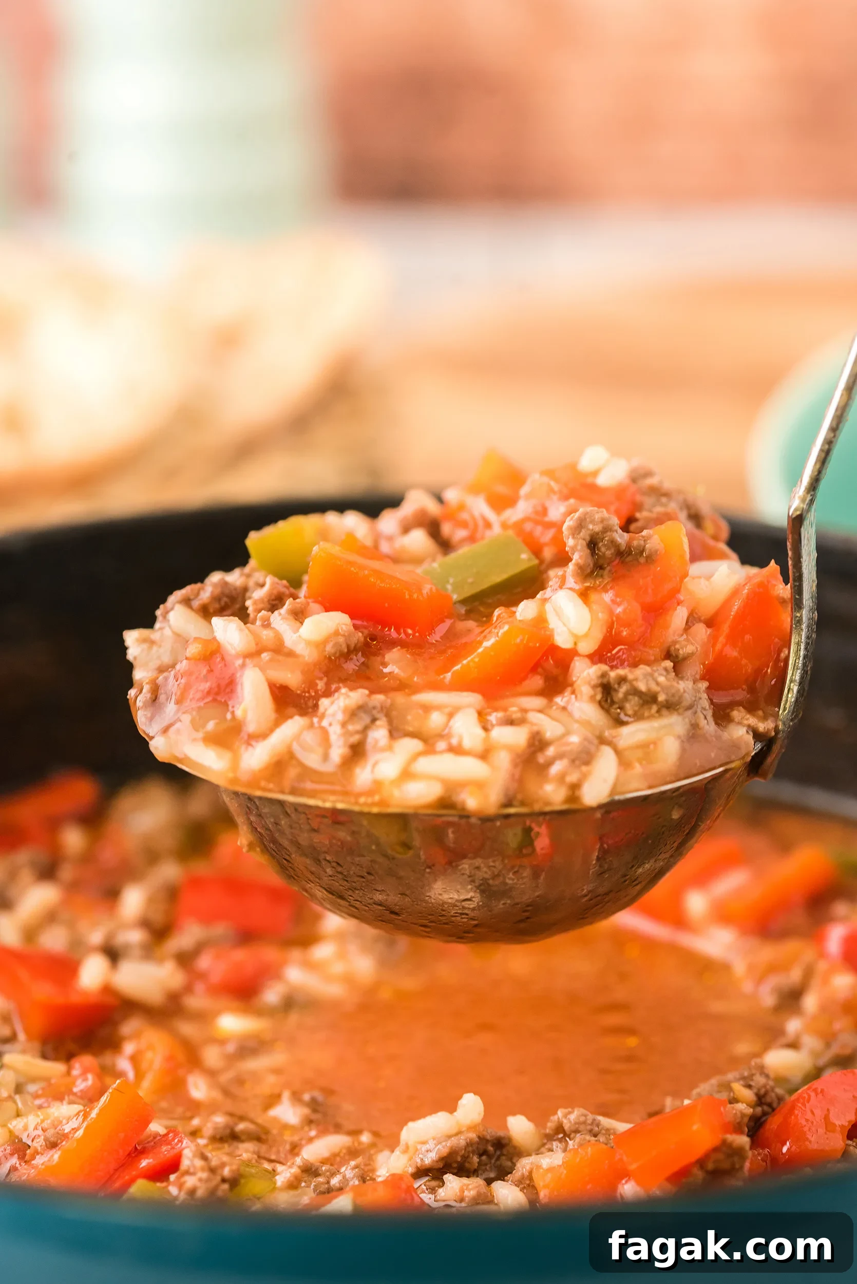 closeup shot of a ladle full of soup, with a wooden background