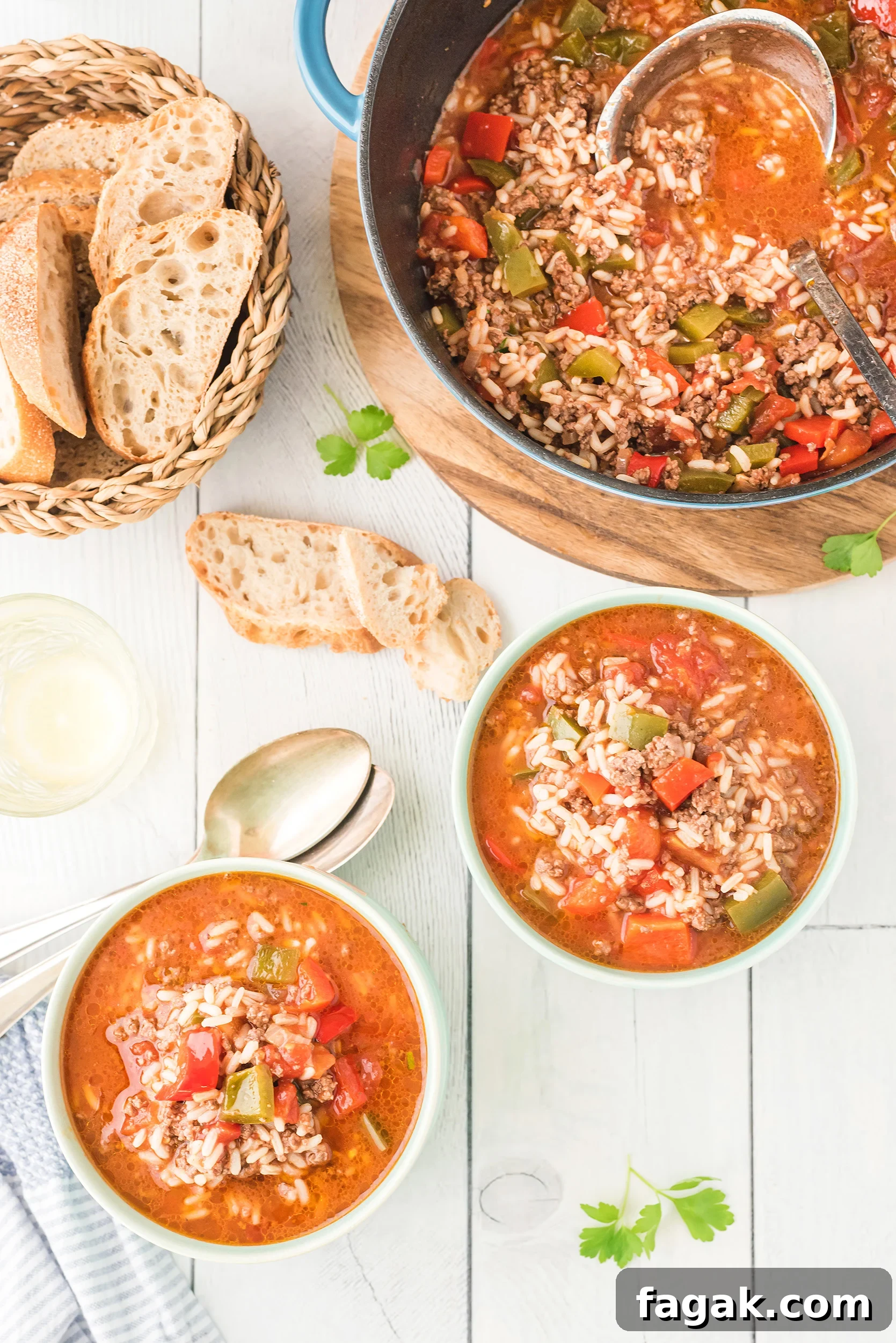 two bowls of stuffed pepper soup with crusty bread on the side. The large soup pot is in the background