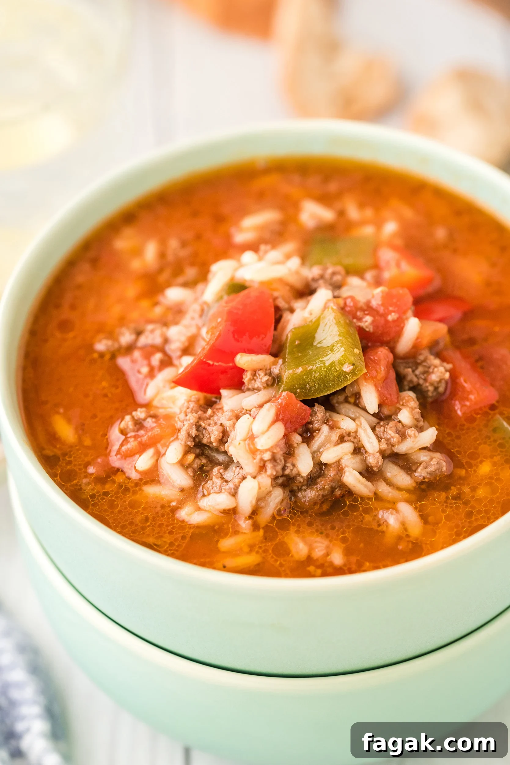 two stacked mint green bowls bowls filled with stuffed pepper soup