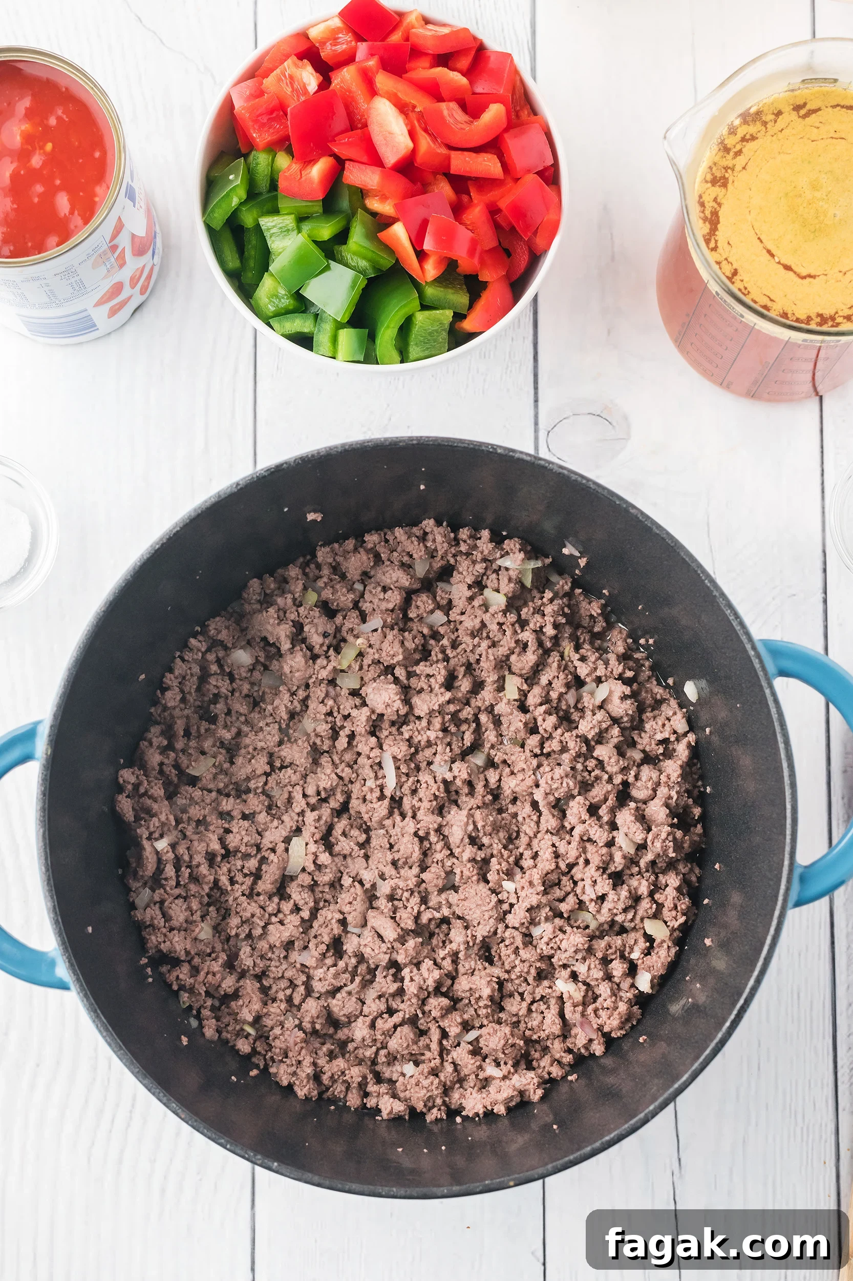 sautéed ground beef, onions and garlic in a Dutch oven on a white board