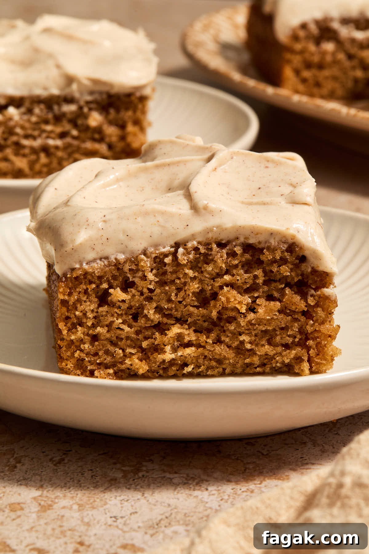 Side view of a piece of chai cake on a plate with pieces in the background.