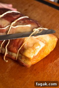 cutting the kitchen twine of a smoked pork loin roast