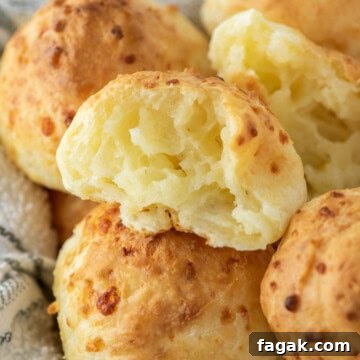 Bite of Brazilian cheese bread taken out with others in bowl.