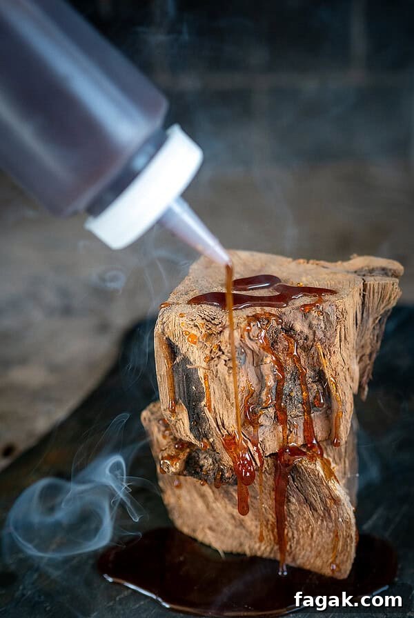 Drizzling hot honey on wood with smoke in background.