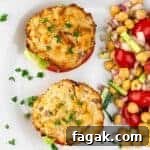 Easy to make air fryer tuna patties served with lettuce, tomato, and chickpea salad, garnished with parsley.