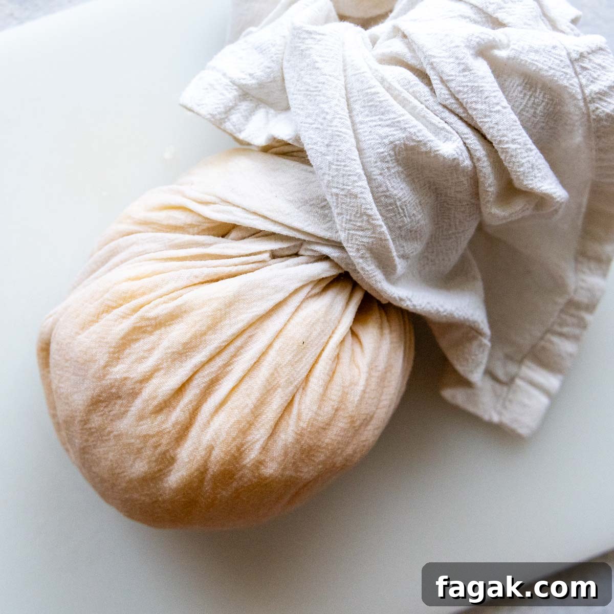 potatoes being squeezed in a towel to remove excess moisture.
