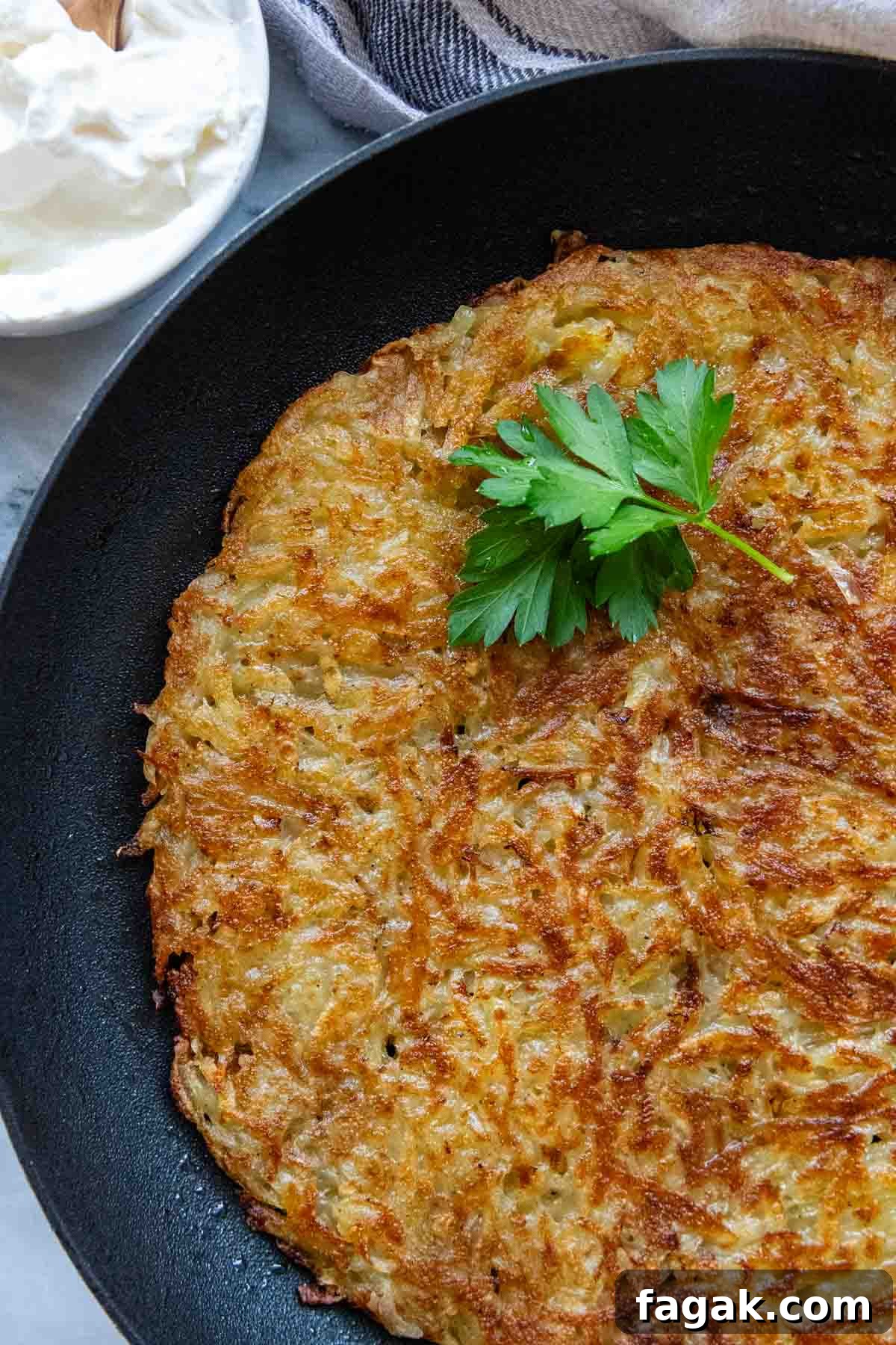 potato rosti in a skillet with parsley garnish.