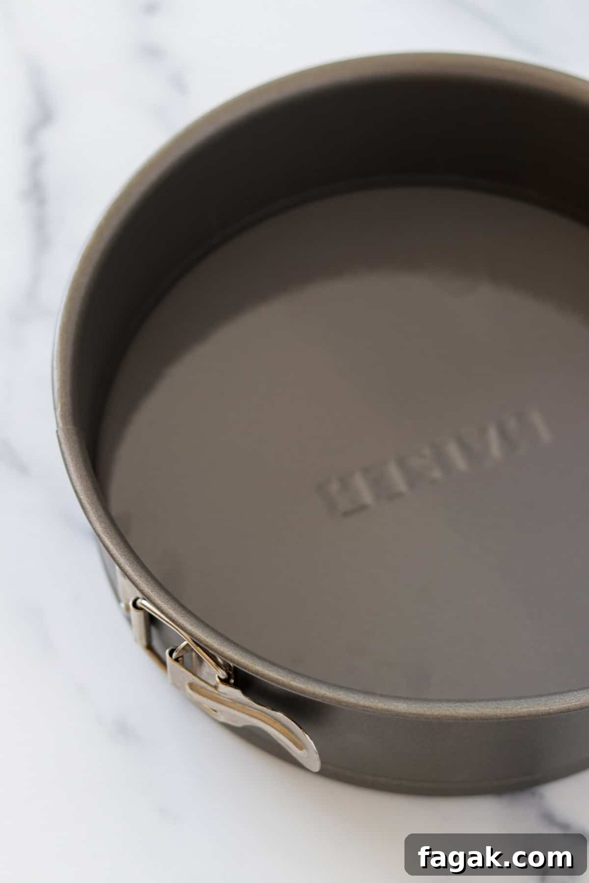 A springform pan on a marble surface.