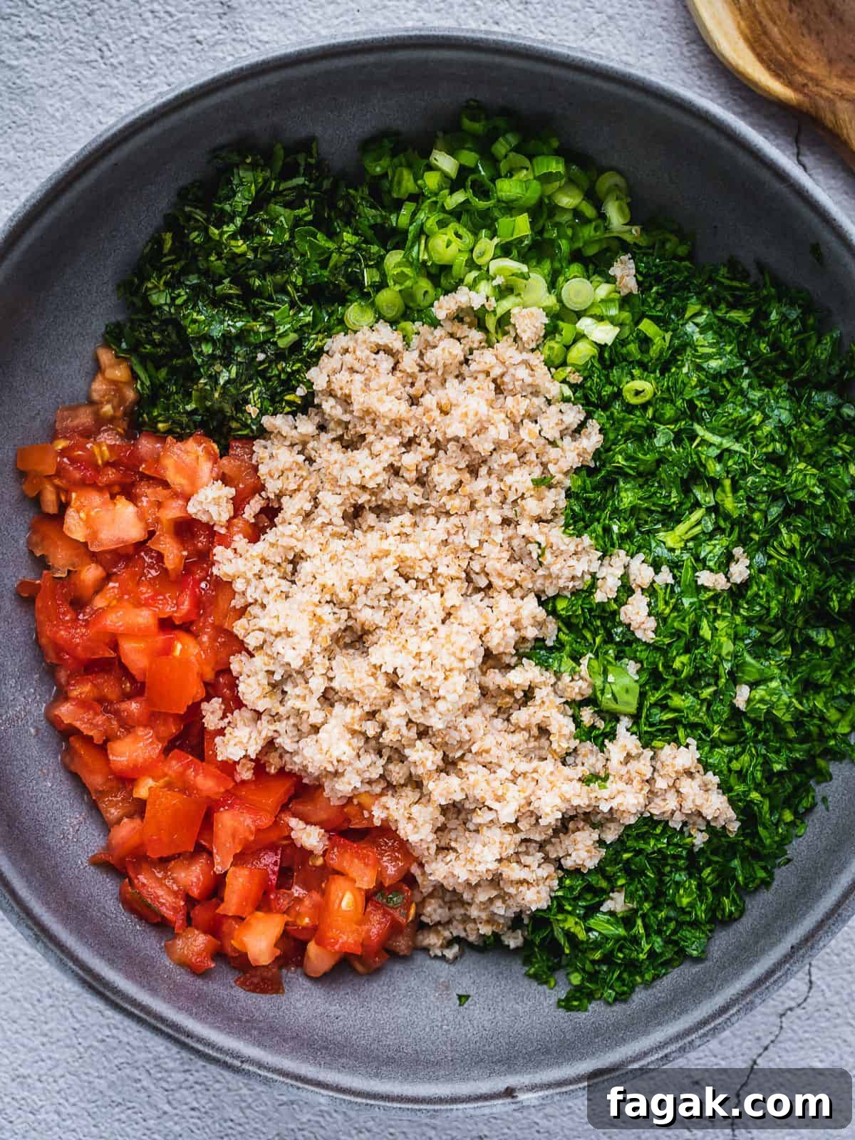 The bulgur wheat is added to the tabbouleh ingredients.