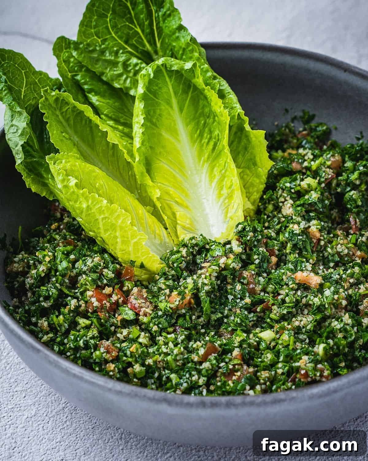 Tabbouleh salad in a bowl with romaine lettuce hearts.