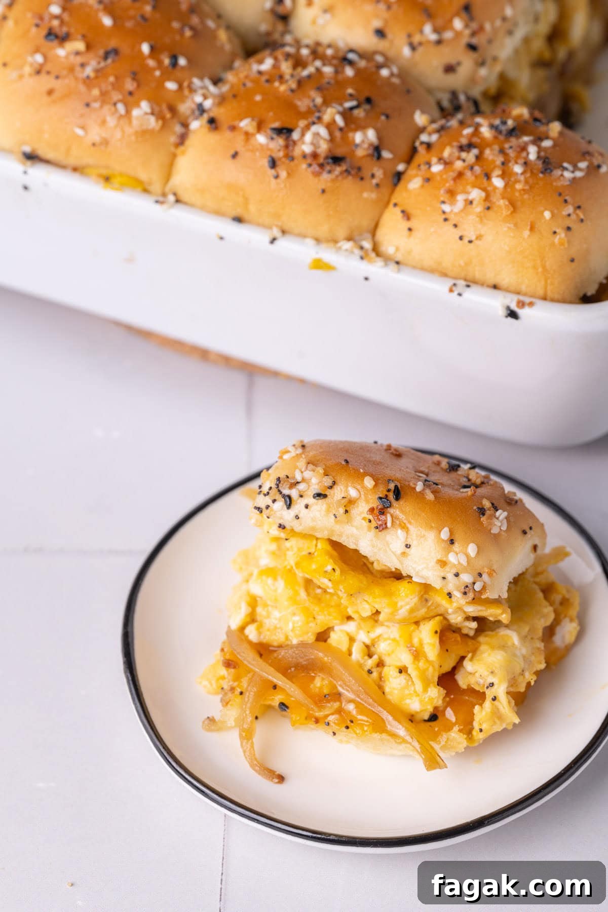 Tiny plate with a Hawaiian roll breakfast slider fresh out of the oven.