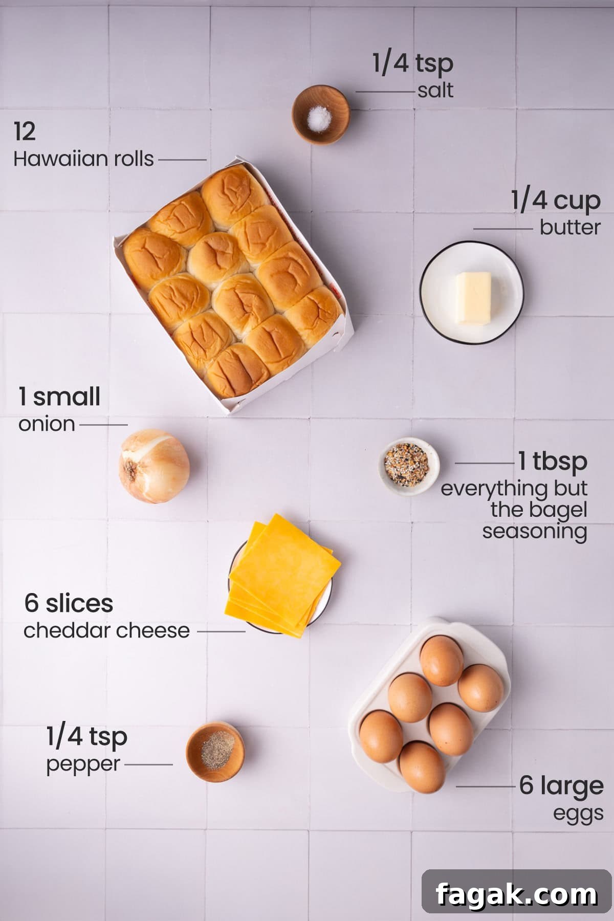Overhead view of all ingredients for Hawaiian Roll Breakfast Sliders - salt, Hawaiian rolls, butter, onion, everything but the bagel seasoning, cheddar cheese, pepper, and eggs.